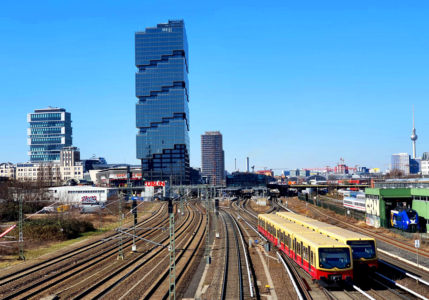Stadtansicht mit moderner Hochhausbebauung und Bahntrassen als Beispiel für die Bewertung von Lage, Infrastruktur und Umfeld.