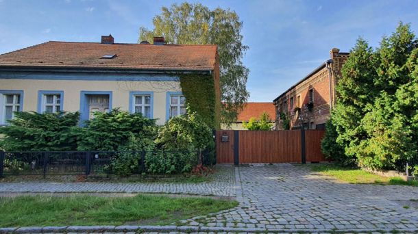 Wohnimmobilie mit Einfamilienhaus und Nebengebäude, Hofeinfahrt und Garten als Beispiel für Immobilienbewertung.